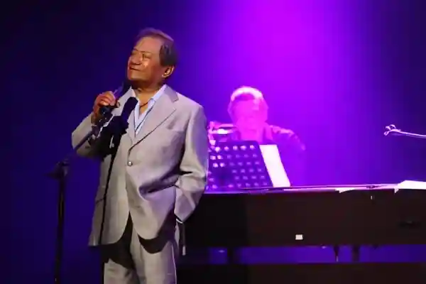 Imagen de Armando Manzanero durante un concierto, como imagen destacada para el post .de Bolero Contigo aprendí letra